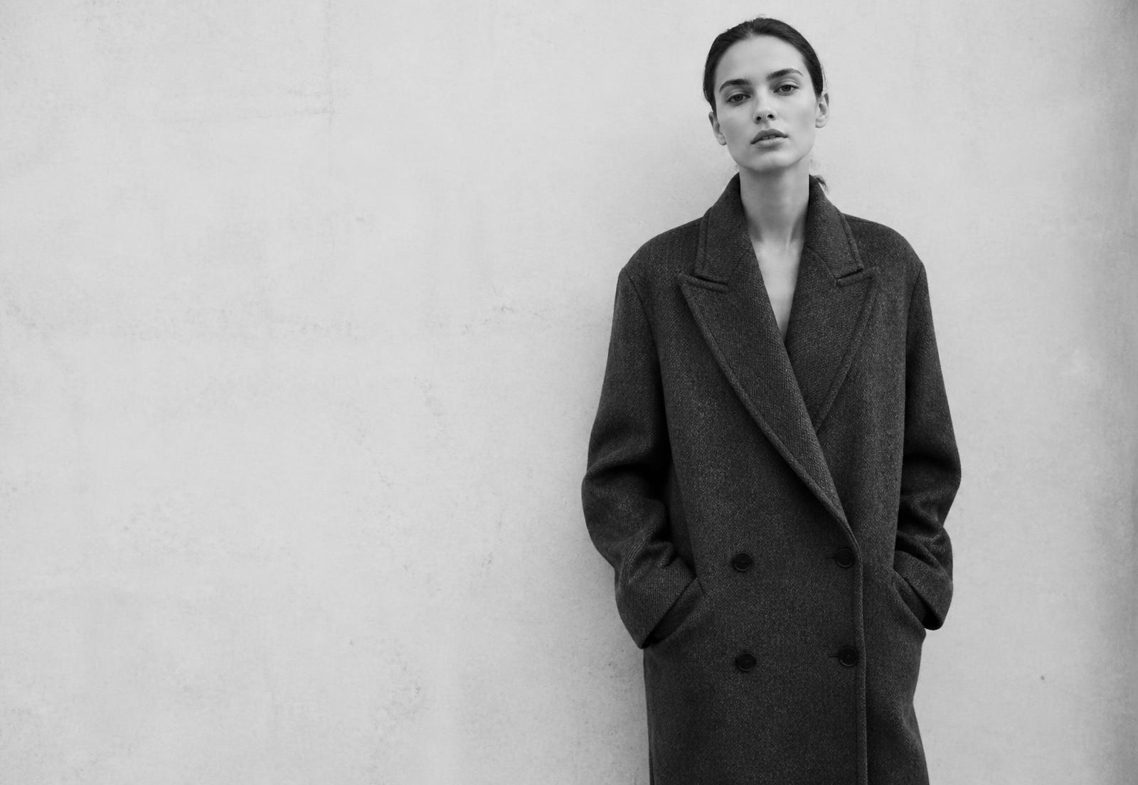 Vyntora model wearing a tailored wool overcoat against a concrete wall